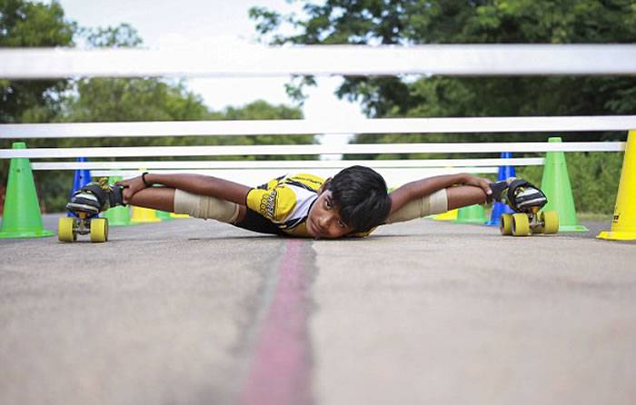 印度8岁男孩Prasad表演惊人绝活：贴地溜冰穿过53辆汽车底盘