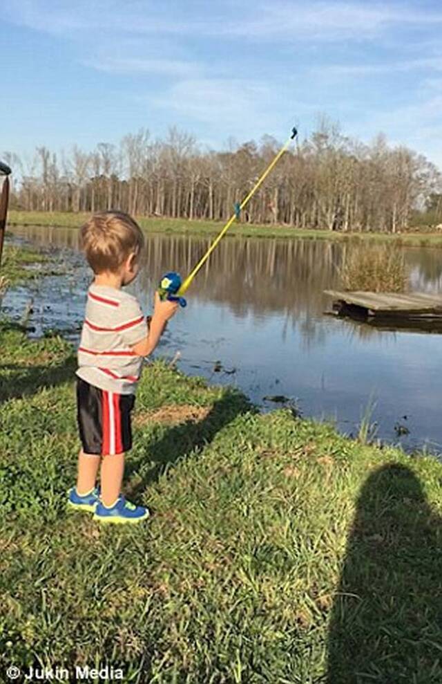 美国阿拉巴马州小男孩和家人去湖边钓鱼 第一次尝试用玩具钓竿竟然真钓起一条鱼