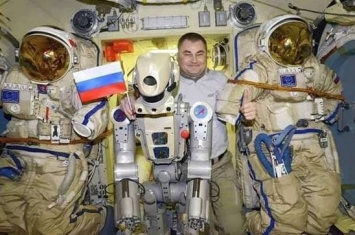 俄罗斯宇航员亚历山大·斯科沃佐夫在国际空间站教人形机器人费奥多尔用毛巾擦汗