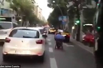 西班牙马路上演惊人一幕：坐轮椅男子在路上飞驰险象横生