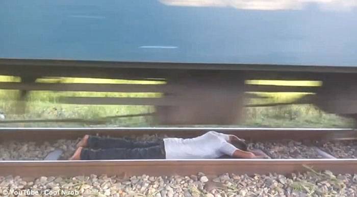 孟加拉国男子玩命伏到路轨上任由高速驶至的火车在头上掠过
