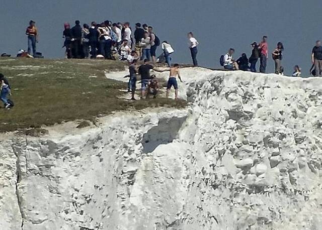 游客玩命站在英国东萨塞克斯郡著名的七姐妹断崖