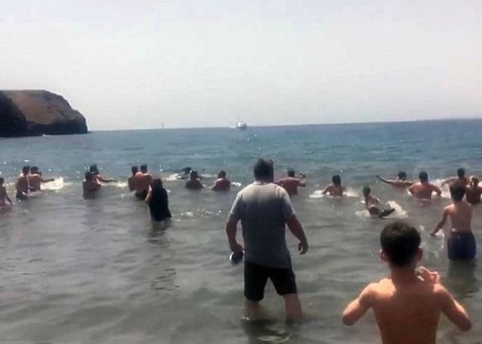 10条鲸鱼搁浅西班牙海滩 大批泳客立刻上前营救