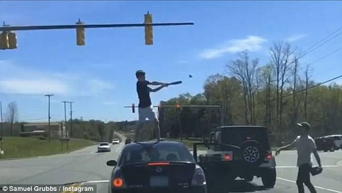 美国北卡罗莱纳州青年恶玩“红灯棒球” 击中后跳上别人车顶庆祝